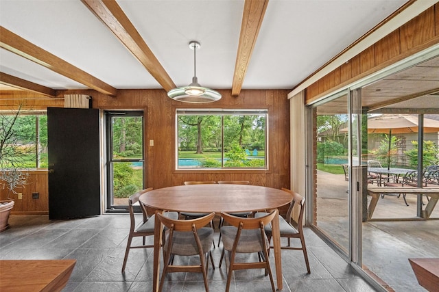 1710 Magnolia Ln, Kingwood, TX 77339 - dining space with beamed ceiling, wood walls, and stone tile floors