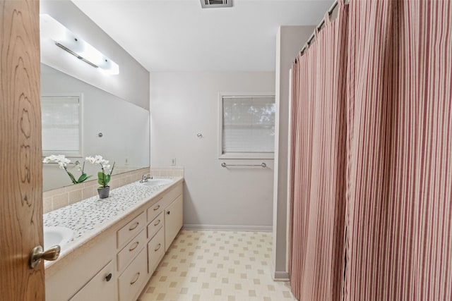 1710 Magnolia Ln, Kingwood, TX 77339 - full bathroom featuring double vanity, tile patterned floors, and baseboards