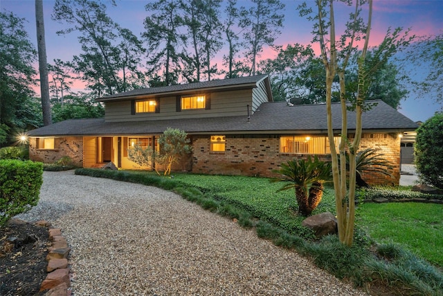 1710 Magnolia Ln, Kingwood, TX 77339 - traditional-style house with brick siding, gravel driveway, a front yard, and roof with shingles