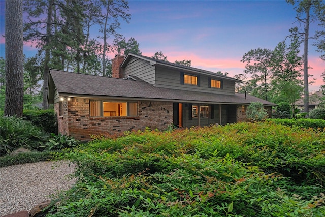 1710 Magnolia Ln, Kingwood, TX 77339 - view of front of home featuring brick siding, a chimney, and roof with shingles