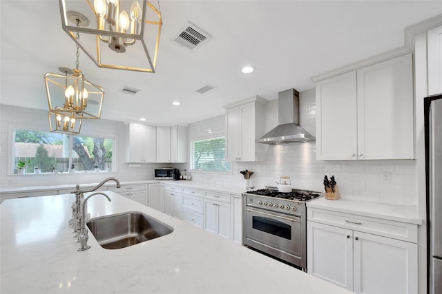 1345 Curtin St, Houston, TX 77018 - kitchen featuring wall chimney range hood, high end range, a chandelier, a sink, and backsplash