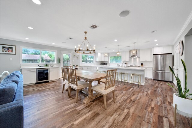 1345 Curtin St, Houston, TX 77018 - dining area with wine cooler, light wood finished floors, recessed lighting, a chandelier, and crown molding