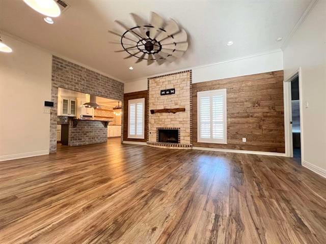 225 Lexington Dr, Vidor, TX 77662 - unfurnished living room featuring a brick fireplace, ornamental molding, wood finished floors, and baseboards