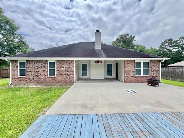 225 Lexington Dr, Vidor, TX 77662 - rear view of house featuring a chimney, an outdoor fire pit, brick siding, and a deck
