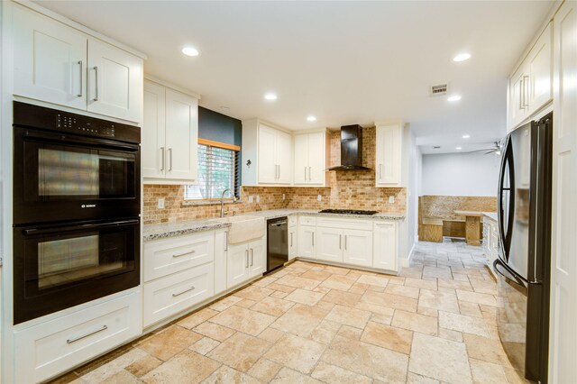 4438 Wigton Dr, Houston, TX 77096 - kitchen with wall chimney range hood, black appliances, a sink, decorative backsplash, and white cabinets