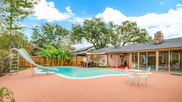4438 Wigton Dr, Houston, TX 77096 - view of swimming pool with a water slide, a patio, and a fenced backyard