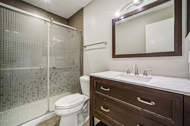 4747 Nasa Pkwy Unit 104, Pasadena, TX 77586 - full bath featuring toilet, vanity, a shower stall, tile patterned floors, and a textured wall