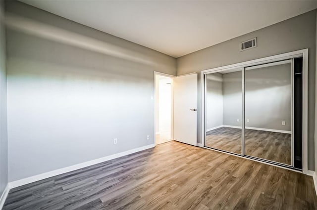 4747 Nasa Pkwy Unit 104, Pasadena, TX 77586 - unfurnished bedroom with wood finished floors, baseboards, and a closet