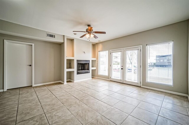 4747 Nasa Pkwy Unit 104, Pasadena, TX 77586 - unfurnished living room with light tile patterned flooring, built in shelves, french doors, ceiling fan, and baseboards