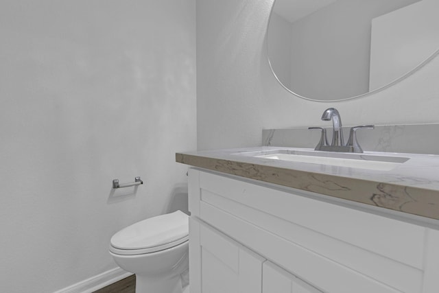 7918 Swan Ln, Baytown, TX 77523 - half bath featuring vanity, toilet, wood finished floors, and baseboards