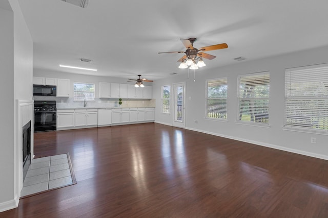 7918 Swan Ln, Baytown, TX 77523 - unfurnished living room with a ceiling fan, healthy amount of natural light, dark wood-type flooring, and baseboards