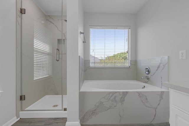 7918 Swan Ln, Baytown, TX 77523 - bathroom with a marble finish shower, vanity, a garden tub, and wood finished floors