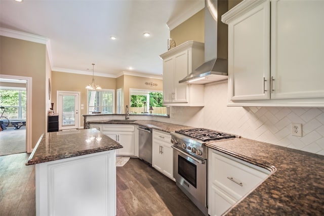 143 Park Way, Montgomery, TX 77356 - kitchen featuring appliances with stainless steel finishes, a peninsula, dark wood-style flooring, plenty of natural light, and ornamental molding