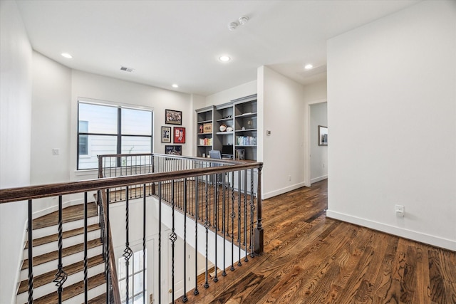hallway featuring an upstairs landing, wood finished floors, recessed lighting, and baseboards