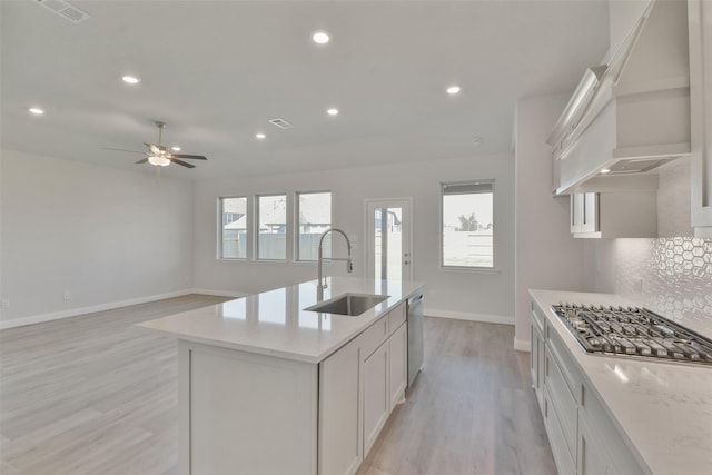 13140 Soaring Forest Dr, Conroe, TX 77302 - kitchen with a sink, stainless steel appliances, custom range hood, light wood-type flooring, and baseboards