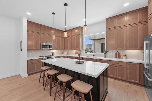 1503 Vermont St Unit D, Houston, TX 77006 - kitchen featuring appliances with stainless steel finishes, light wood-style floors, a breakfast bar area, tasteful backsplash, and recessed lighting