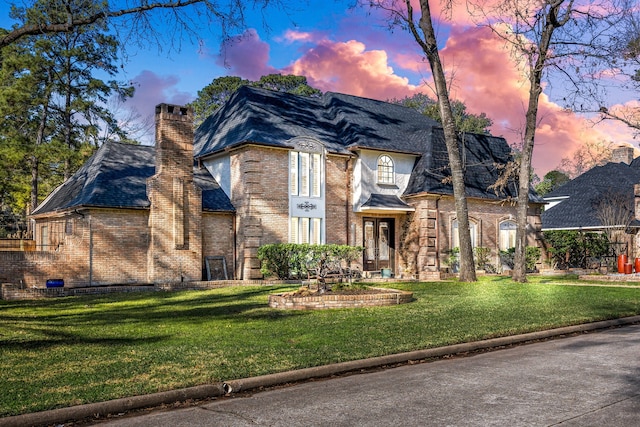 16019 Mickleham Dr, Spring, TX 77379 - view of front of home with brick siding, a chimney, and a yard