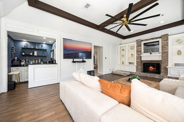 16019 Mickleham Dr, Spring, TX 77379 - living room with ceiling fan, bar area, a fireplace, dark wood finished floors, and beam ceiling