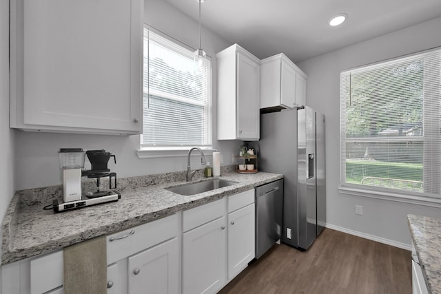 9040 Pecos Pl, Willis, TX 77378 - kitchen featuring stainless steel appliances, a sink, dark wood finished floors, white cabinets, and plenty of natural light