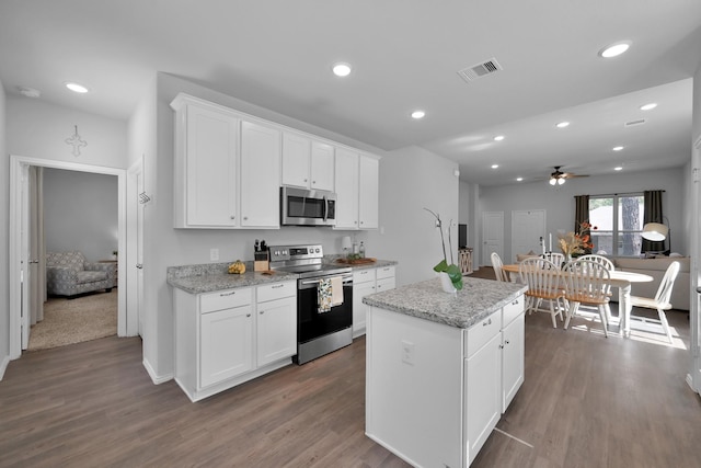 9040 Pecos Pl, Willis, TX 77378 - kitchen featuring stainless steel appliances, ceiling fan, a kitchen island, dark wood-style flooring, and recessed lighting