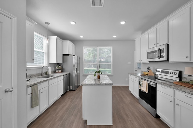 9040 Pecos Pl, Willis, TX 77378 - kitchen with appliances with stainless steel finishes, a sink, a kitchen island, healthy amount of natural light, and recessed lighting