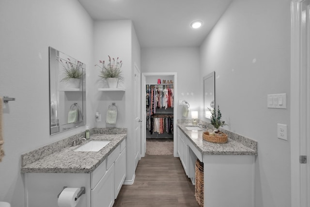 9040 Pecos Pl, Willis, TX 77378 - full bath with two vanities, wood finished floors, a walk in closet, recessed lighting, and baseboards