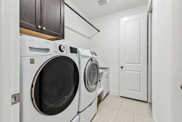 15003 Big Spring Park Dr, Cypress, TX 77433 - washroom featuring washer and dryer, cabinet space, light tile patterned floors, and baseboards