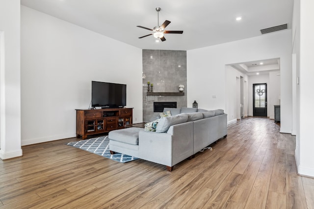 15003 Big Spring Park Dr, Cypress, TX 77433 - living room with ceiling fan, light wood-type flooring, a tiled fireplace, baseboards, and recessed lighting