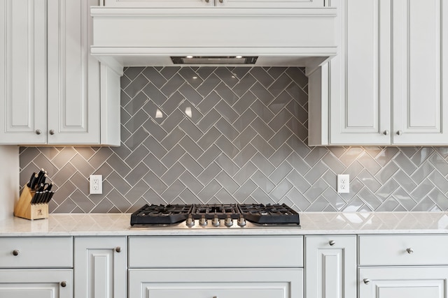 15003 Big Spring Park Dr, Cypress, TX 77433 - kitchen featuring stainless steel gas stovetop, backsplash, white cabinetry, and premium range hood