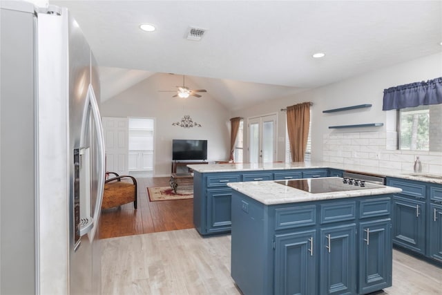 2207 Azalea Cir, Huntsville, TX 77340 - kitchen with stainless steel fridge, blue cabinetry, a peninsula, black electric cooktop, and a ceiling fan