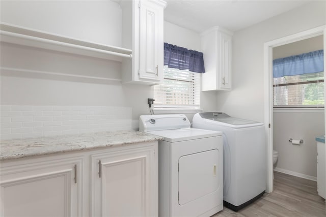 2207 Azalea Cir, Huntsville, TX 77340 - washroom with washing machine and dryer, plenty of natural light, light wood-type flooring, and cabinet space