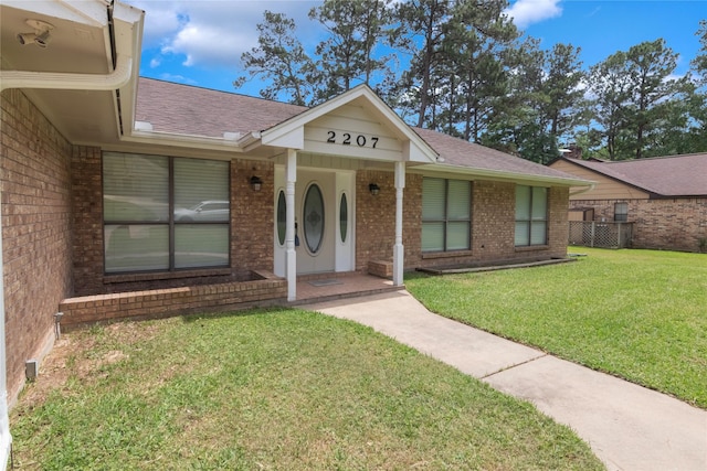 2207 Azalea Cir, Huntsville, TX 77340 - ranch-style home with brick siding, a shingled roof, and a front yard
