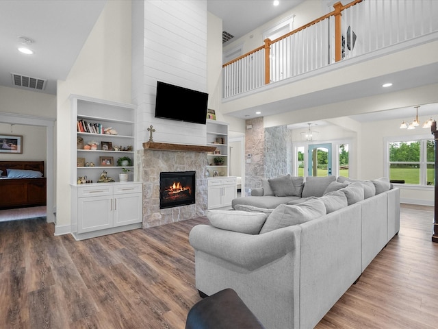 8253 Carolyn St, Santa Fe, TX 77517 - living room featuring a high ceiling, a fireplace, wood finished floors, a chandelier, and recessed lighting