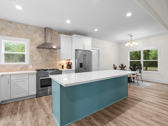 8253 Carolyn St, Santa Fe, TX 77517 - kitchen with stainless steel appliances, wall chimney range hood, light countertops, healthy amount of natural light, and recessed lighting