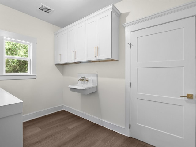 8253 Carolyn St, Santa Fe, TX 77517 - laundry area with dark wood finished floors and baseboards