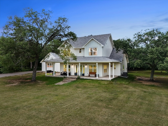 8253 Carolyn St, Santa Fe, TX 77517 - back of property featuring a porch, central AC unit, a shingled roof, and a lawn