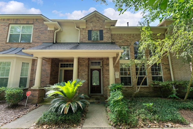 27 Medley Ln, The Woodlands, TX 77382 - view of front of property with brick siding, a porch, and a shingled roof