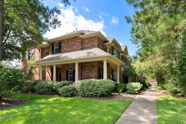 27 Medley Ln, The Woodlands, TX 77382 - view of front of home with brick siding, a front yard, and a shingled roof