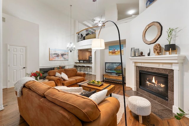 27 Medley Ln, The Woodlands, TX 77382 - living area featuring a high ceiling, wood finished floors, a tiled fireplace, and a ceiling fan