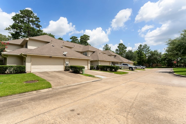 27 Medley Ln, The Woodlands, TX 77382 - view of front facade with driveway, an attached garage, a shingled roof, and a front yard
