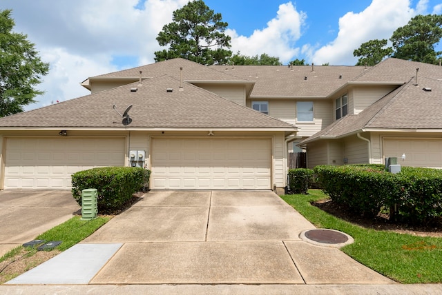 27 Medley Ln, The Woodlands, TX 77382 - view of front facade with concrete driveway, an attached garage, and a shingled roof