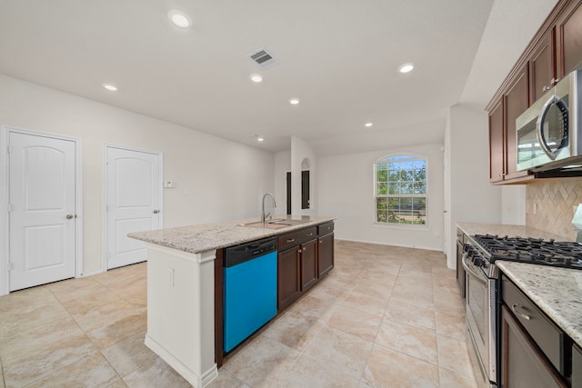 3105 Zachary Bay Ln, League City, TX 77539 - kitchen featuring appliances with stainless steel finishes, a sink, an island with sink, tasteful backsplash, and light stone counters