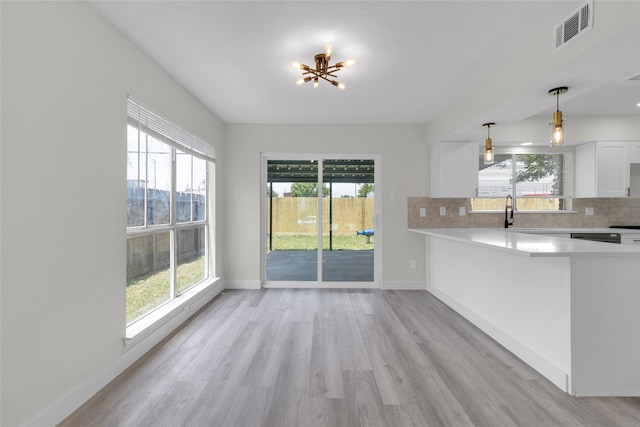 18010 Santolina Ln, Katy, TX 77449 - kitchen featuring light countertops, light wood-style floors, white cabinetry, and plenty of natural light