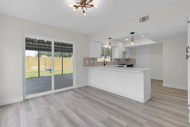 18010 Santolina Ln, Katy, TX 77449 - kitchen with light countertops, light wood finished floors, backsplash, and a peninsula