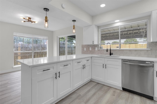 18010 Santolina Ln, Katy, TX 77449 - kitchen featuring dishwasher, a sink, a peninsula, light countertops, and tasteful backsplash