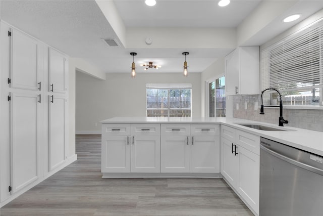 18010 Santolina Ln, Katy, TX 77449 - kitchen featuring dishwasher, a sink, a peninsula, white cabinets, and recessed lighting