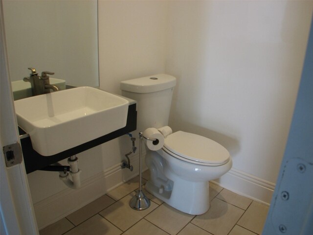 2405 Keene St, Houston, TX 77009 - bathroom with toilet, baseboards, tile patterned flooring, and a sink