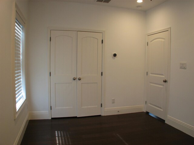 2405 Keene St, Houston, TX 77009 - unfurnished bedroom with dark wood-style flooring, baseboards, multiple windows, a closet, and recessed lighting