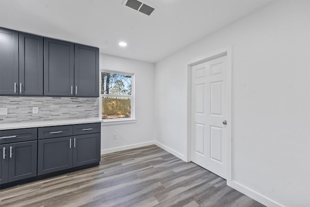 205 Elmwood St, Huntsville, TX 77320 - kitchen featuring light countertops, light wood-type flooring, backsplash, recessed lighting, and baseboards