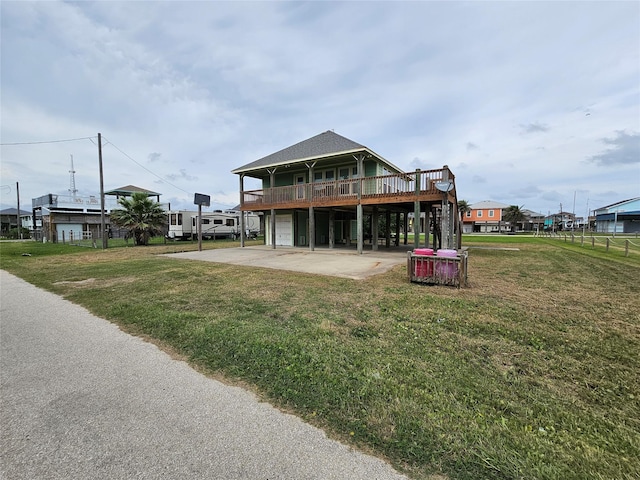 970 Olive Dr, Crystal Beach, TX 77650 - rear view of property with a yard, an attached garage, a deck, and driveway